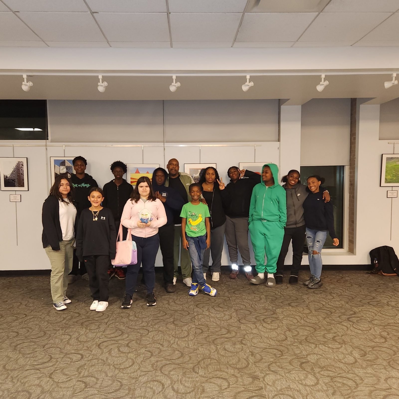 A large group of CCWW youth and mentors in an art gallery space